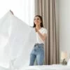 Welche Bettwäsche ist bügelfrei: Frau bezieht ein Bett