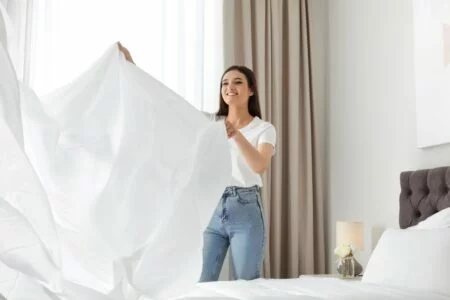Welche Bettwäsche ist bügelfrei: Frau bezieht ein Bett
