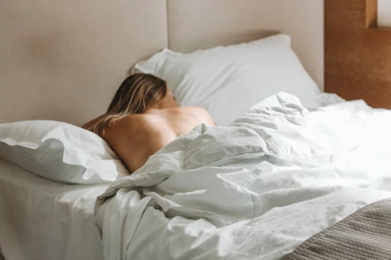 falsches kopfkissen symptome: Frau liegt im Bett und schläft.