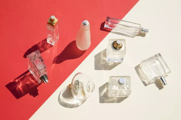 Beste Parfums Damen: Parfumflaschen auf weiß-rotem Hintergrund