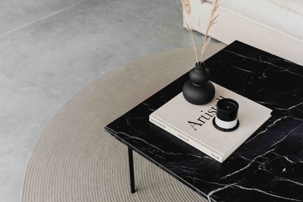 skandinavische Einrichtung: schwarzer Marmortisch auf Juteteppich