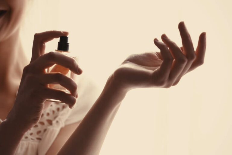 Patchouli Parfum: Frau sprüht Parfum auf