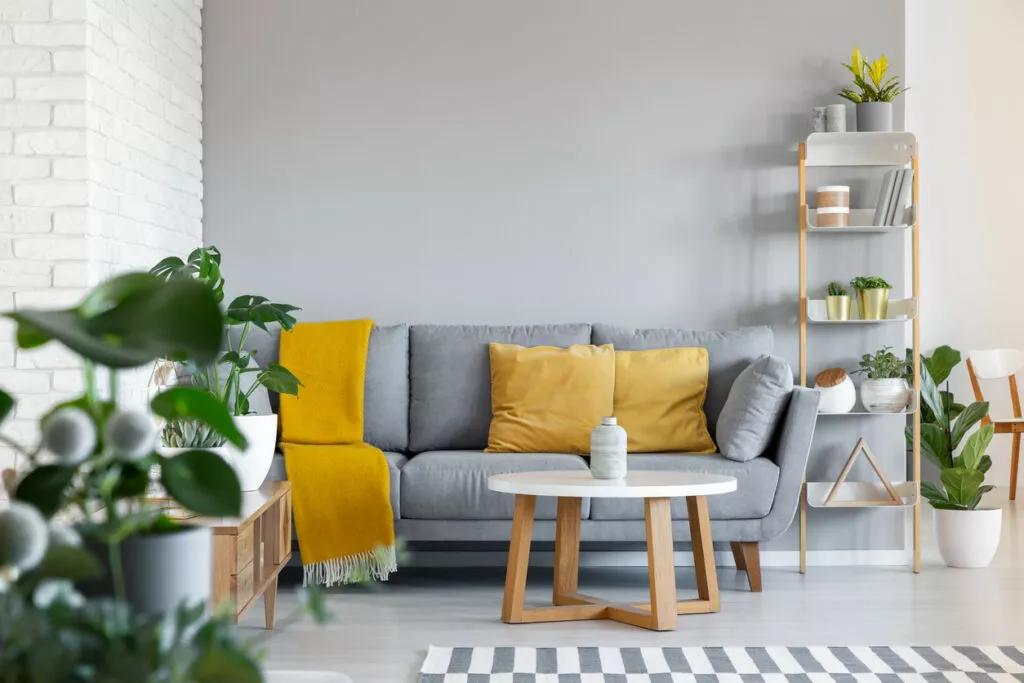 Graues Sofa mit Kissen dekorieren: Gelbe Kissen auf grauem Sofa