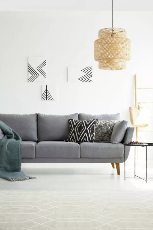 Graues Sofa mit Kissen dekorieren: Schwarz-weiß gemusterte Kissen